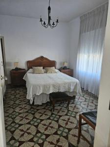 1 dormitorio con cama y lámpara de araña en La Nava, casa de pueblo con patio y calefacción con chimenea, en Nava de la Asunción