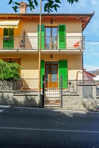 una casa con porte verdi e un balcone di CASA REFENERO a Torrita di Siena