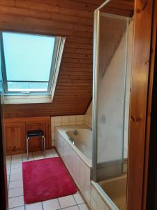 a bathroom with a bath tub and a window at Ferienwohnung Stablo in Kommen +11 photos