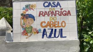 a sign for a restaurant with a woman on a tile wall at A Casa da Rapariga de Cabelo Azul in Manteigas