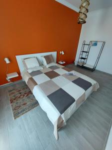 a bedroom with a large bed with an orange wall at AL - Comfortable House in Faro