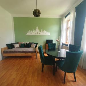salon z łóżkiem, stołem i krzesłami w obiekcie Finka Monika w Dreźnie