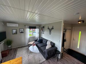 a living room with a couch and a table at Premium Stuga, Near Göta Canal & Tiveden National Park in Undenäs