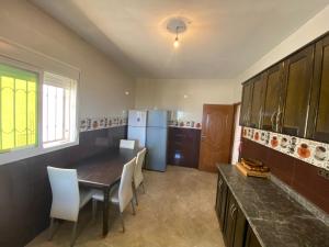 a kitchen with a table and chairs and a refrigerator at Sea house in Nador