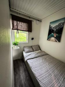 Habitación pequeña con cama y ventana en Cabin On The Hill en Undenäs
