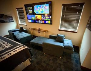 a living room with a couch and a flat screen tv at Bear Mountain - Suite 4 in Grants Pass