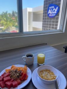 a breakfast plate of fruit and a cup of orange juice at Al&oacute; Select Mazatlan in Mazatl&aacute;n