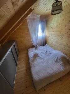 Cette chambre en bois comprend un petit lit et une télévision. dans l'établissement Vikendica-chalet-Nišici, à Ilijaš