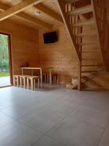 a wooden room with a table and a tv in it at Domek wypoczynkowy in Wydminy