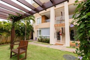 a wooden bench sitting in front of a building at Apartment in Guarajuba with 2 Comfortable Suites. in Guarajuba