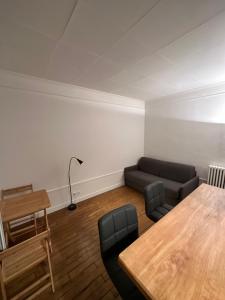 een woonkamer met een tafel en een bank bij Studio idéal proche centre Paris in Boulogne-Billancourt