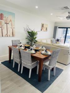 a dining room table and chairs in a living room at U2 at Moana Beach Esplanade - Exclusive 2 Bdrm Apt - WiFi - Spa - Pet Friendly in Moana