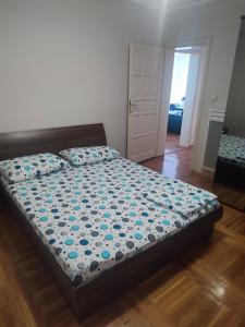 ein Schlafzimmer mit einem Bett mit blauen Blumen darauf in der Unterkunft VILA LUKA in Podgorica