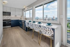 una cocina con armarios azules y una barra con sillas en Breathtaking Views w/ Modern Lux - 2330, en Portland