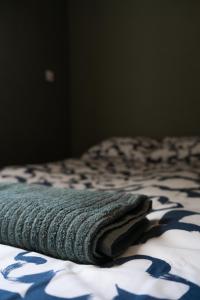 a bed with a blue and white blanket on it at KOWALSKA 8 APARTAMENTY ZRESETUJ SIĘ W GDAŃSKU in Gdańsk