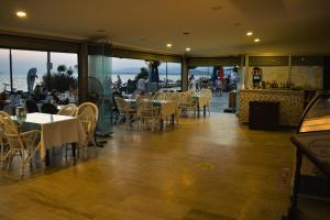 un restaurante con mesas y sillas con vistas al océano en Er-Öz Hotel en Fethiye