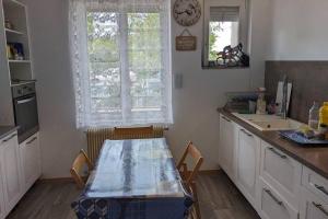 eine Küche mit einem Tisch, einem Waschbecken und einem Fenster in der Unterkunft calme rez-de-chaussée 2 Chambres 70 M2 in Roanne