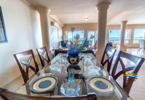 uma sala de jantar com uma mesa de vidro e cadeiras em Steps to the BEACH Las Palmas Condo # 1 em San Felipe