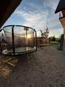 a group of trampolines in a yard with the sunset at Apartament i Pokoje u Łowisza in Ciche