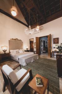 a large bedroom with a bed and a table and chairs at Hotel Boutique Casa Del Arzobispado in Cartagena de Indias