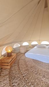 a bedroom with a bed and a table in a tent at Kitesurf Life Glamping in Tutóia