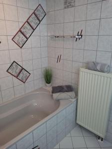 a white bathroom with a tub and a plant in it at Crailsheim Zentral Innenstadt in Crailsheim