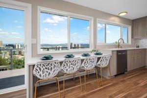 a kitchen with a counter with chairs and windows at Breathtaking Views w/ Modern Lux - 2320 in Portland