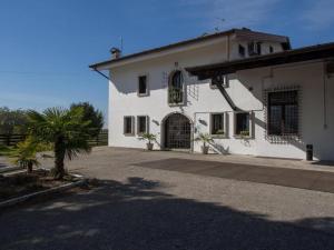 a white house with a palm tree in front of it at Tenuta PARAVANO in Povoletto