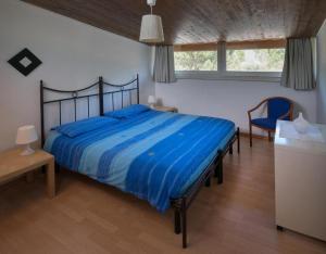 a bedroom with a large bed with a blue comforter at Tenuta PARAVANO in Savorgnano