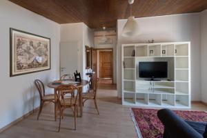 a living room with a dining table and a television at Tenuta PARAVANO in Povoletto