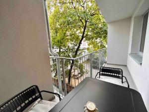 einen Balkon mit einem Tisch und Stühlen sowie einem Fenster in der Unterkunft Urbaner Charme: Stilvolles Wohnen im Herzen Wiens in Wien