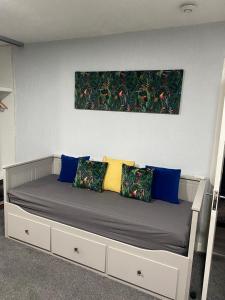 a bed with pillows and a painting on the wall at Saphire Glasgow Apartments in Giffnock