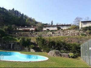 a swimming pool on the side of a hill with houses at Casa Encosta da Caniçada in Vieira do Minho