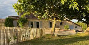 a house with a wooden fence in front of it at Gîte Barn - Tirecul - 24 in Monbazillac
