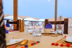 Merzouga Luxury Traditional Camp في مرزوقة: طاولة عليها صحون وصحون