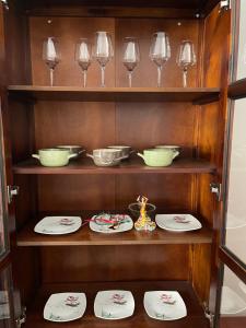 a shelf with plates and wine glasses on it at Authentic Greek Charming Central in Patra