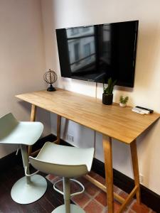 a wooden table with a television on a wall at 101 Studio en plein cœur historique de Bourges in Bourges