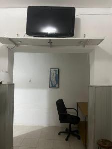 Mono ambiente céntrico Formosa في فورموزا: غرفة بها كرسي وتلفزيون على السقف