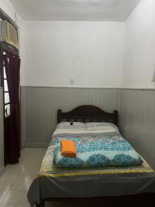 Una cama con una toalla naranja encima. en Mono ambiente céntrico Formosa en Formosa
