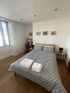 Abergavenny Center 2-Bed Flat في أبرجافني: غرفة نوم عليها سرير وفوط