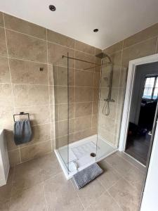 a shower with a glass door in a bathroom at Abergavenny Center 2-Bed Flat in Abergavenny