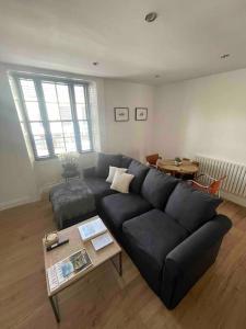 a living room with a black couch and a table at Abergavenny Center 2-Bed Flat in Abergavenny
