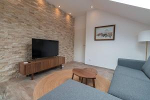 a living room with a tv and a couch and a table at Mountain Valley View in Buşteni