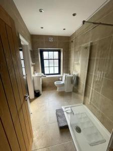 a bathroom with a tub and a toilet and a sink at Abergavenny Center 2-Bed Flat in Abergavenny