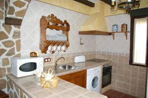 a kitchen with a sink and a microwave at Casa Rural Cristina I in San Pablo de los Montes