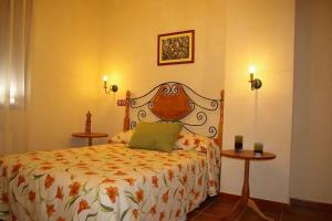 1 dormitorio con 1 cama y 2 mesas en Casa Rural Cristina I en San Pablo de los Montes