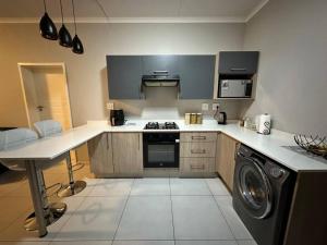 een keuken met een wasmachine en een wasmachine bij Maria’s Place in Midrand