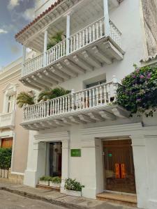 ein weißes Gebäude mit einem Balkon und Blumen in der Unterkunft Delirio Hotel in Cartagena de Indias