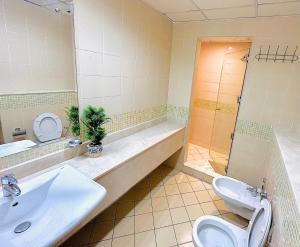 a bathroom with a sink and a toilet and a shower at VIP Hostel - Females Only in Dubai