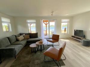 a living room with a couch and a tv at Lakeview villa with swimming and fishing pier in Simonshaven